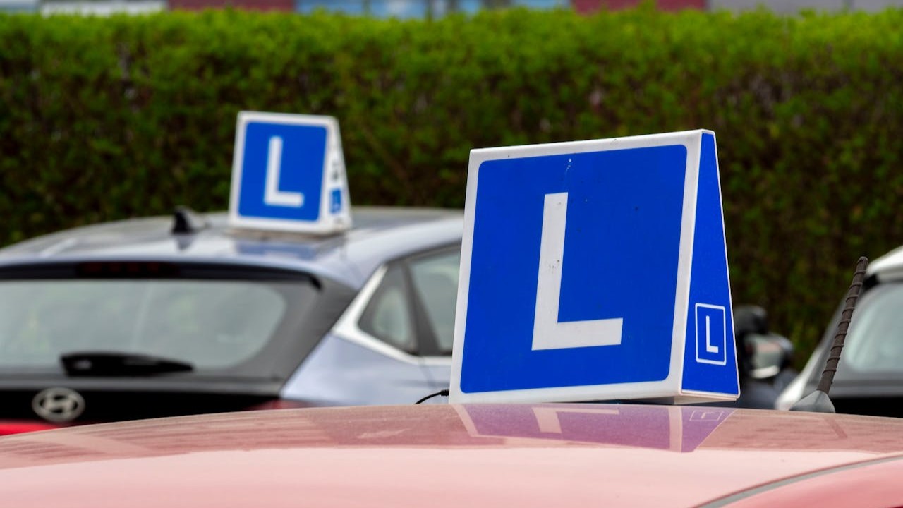 Rijinstructeur geeft uitleg tijdens praktijkles op parkeerterrein, relevant voor prijs rijlessen en lesopbouw